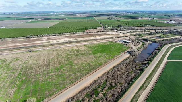 a view of a yard with wooden fence