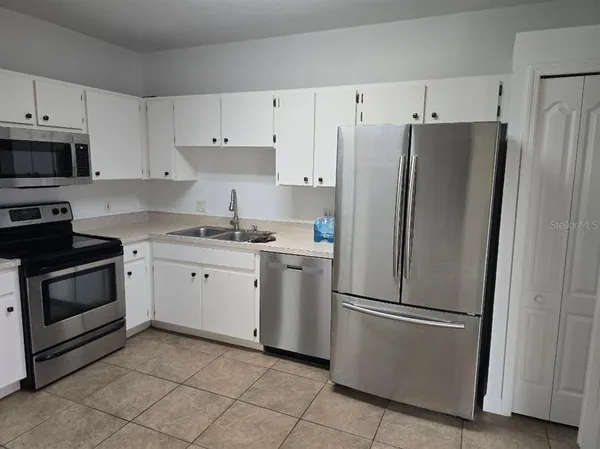 a kitchen with cabinets stainless steel appliances and a counter space