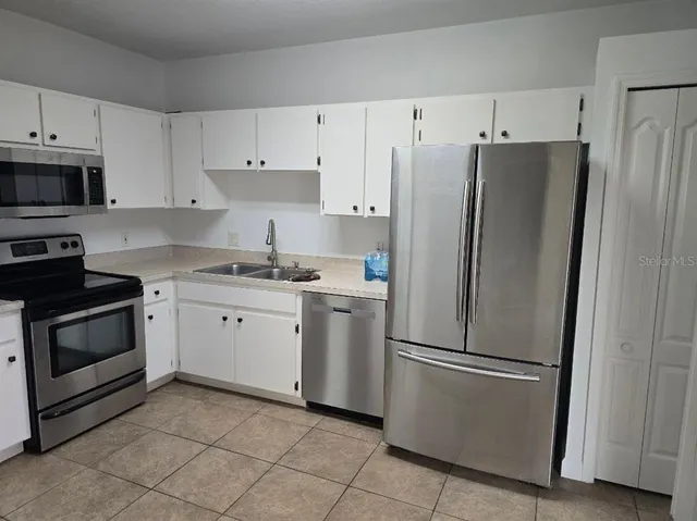a kitchen with cabinets stainless steel appliances and a counter space