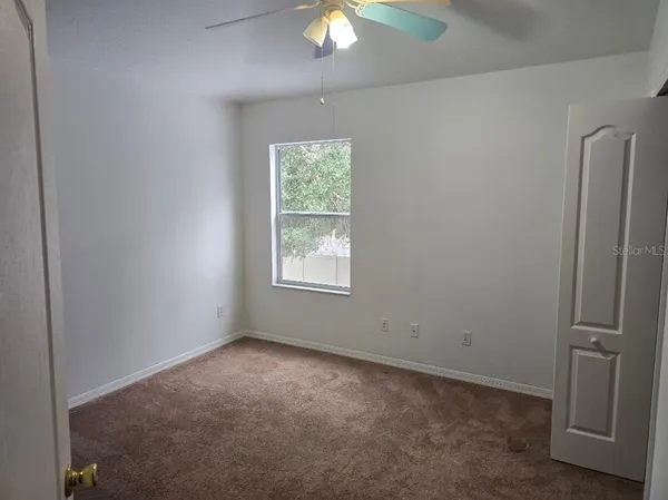 an empty room with closet and a window