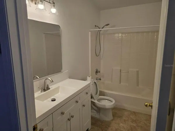 a bathroom with a granite countertop sink a toilet and shower