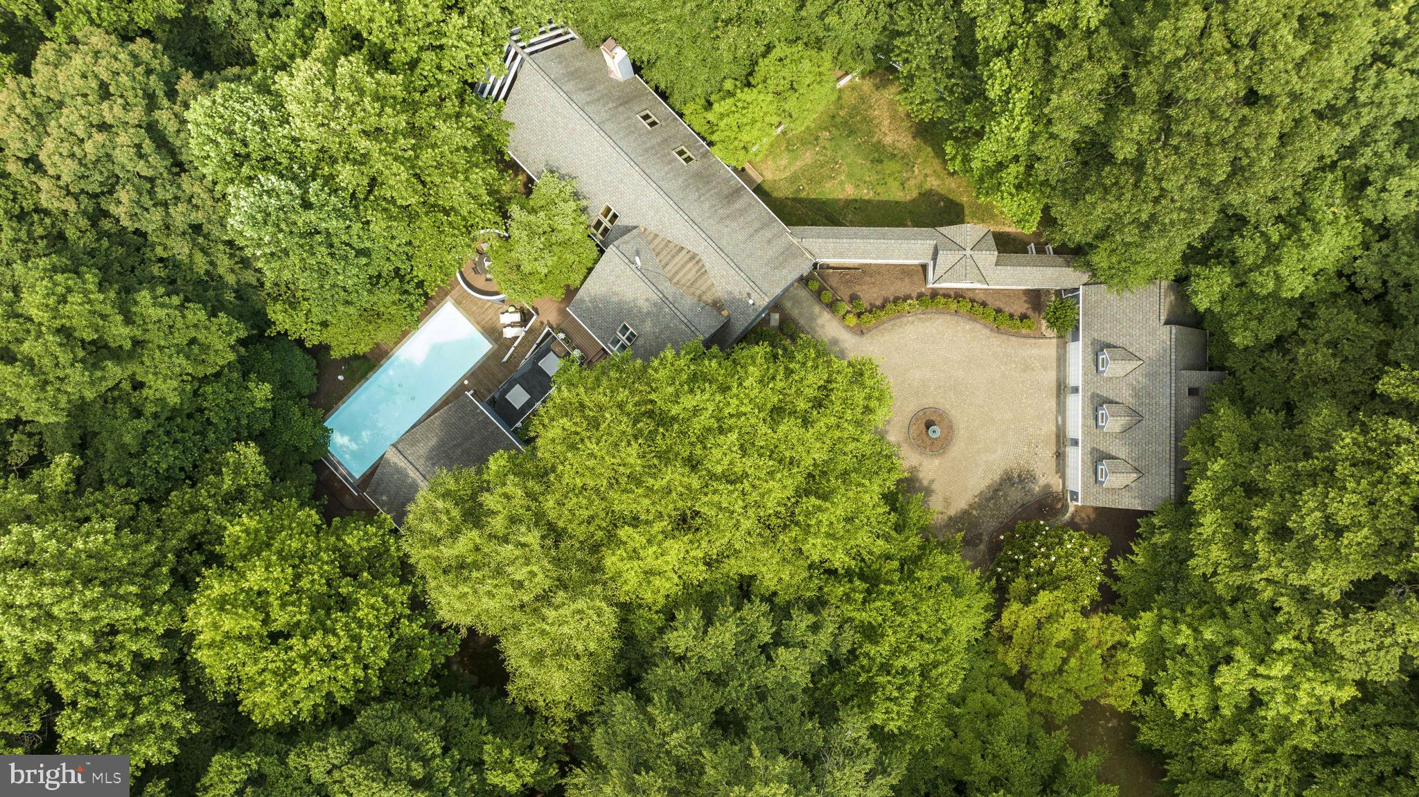 an aerial view of a house with a yard and blue swimming pool