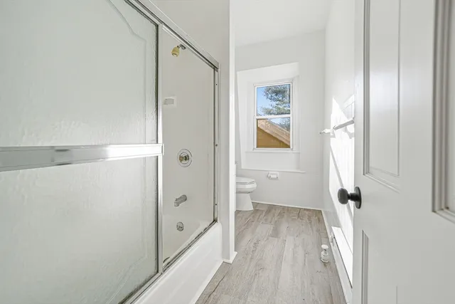 a view of a hallway with wooden floor and staircase