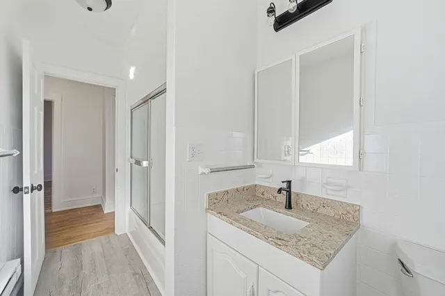 a bathroom with a granite countertop sink and a mirror