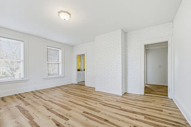 a view of a bedroom with wooden floor and windows