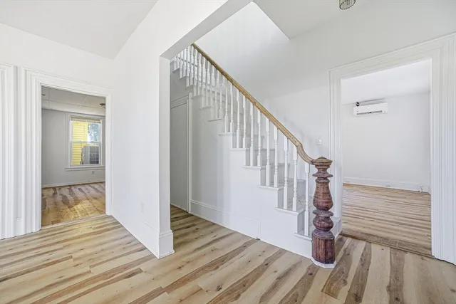a view of a hallway with wooden floor and stairs