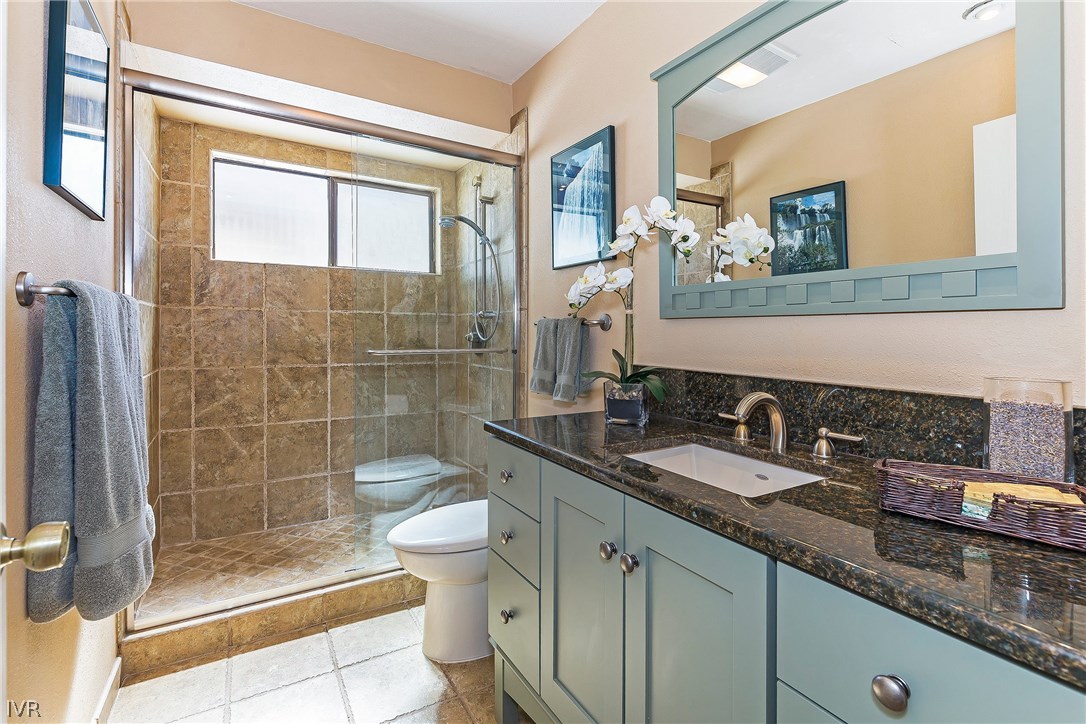 999 Apollo Way Incline Village, NV 89451 - Photo 17 of 33 a bathroom with a granite countertop sink a toilet a mirror and shower