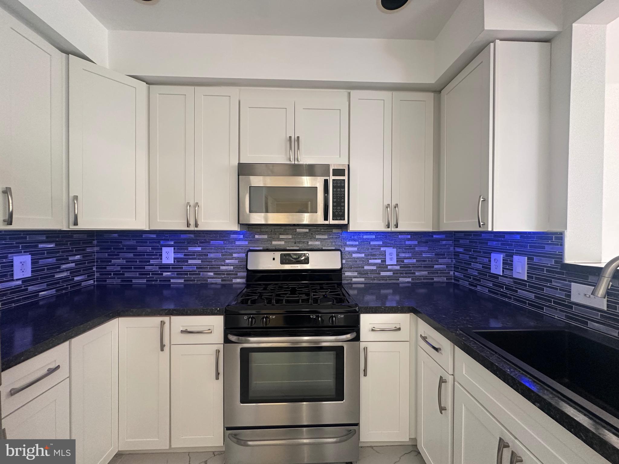 11775 Stratford House Place, Unit 206 Reston, VA 20190 - Photo 11 of 39 a kitchen with granite countertop white cabinets and stainless steel appliances
