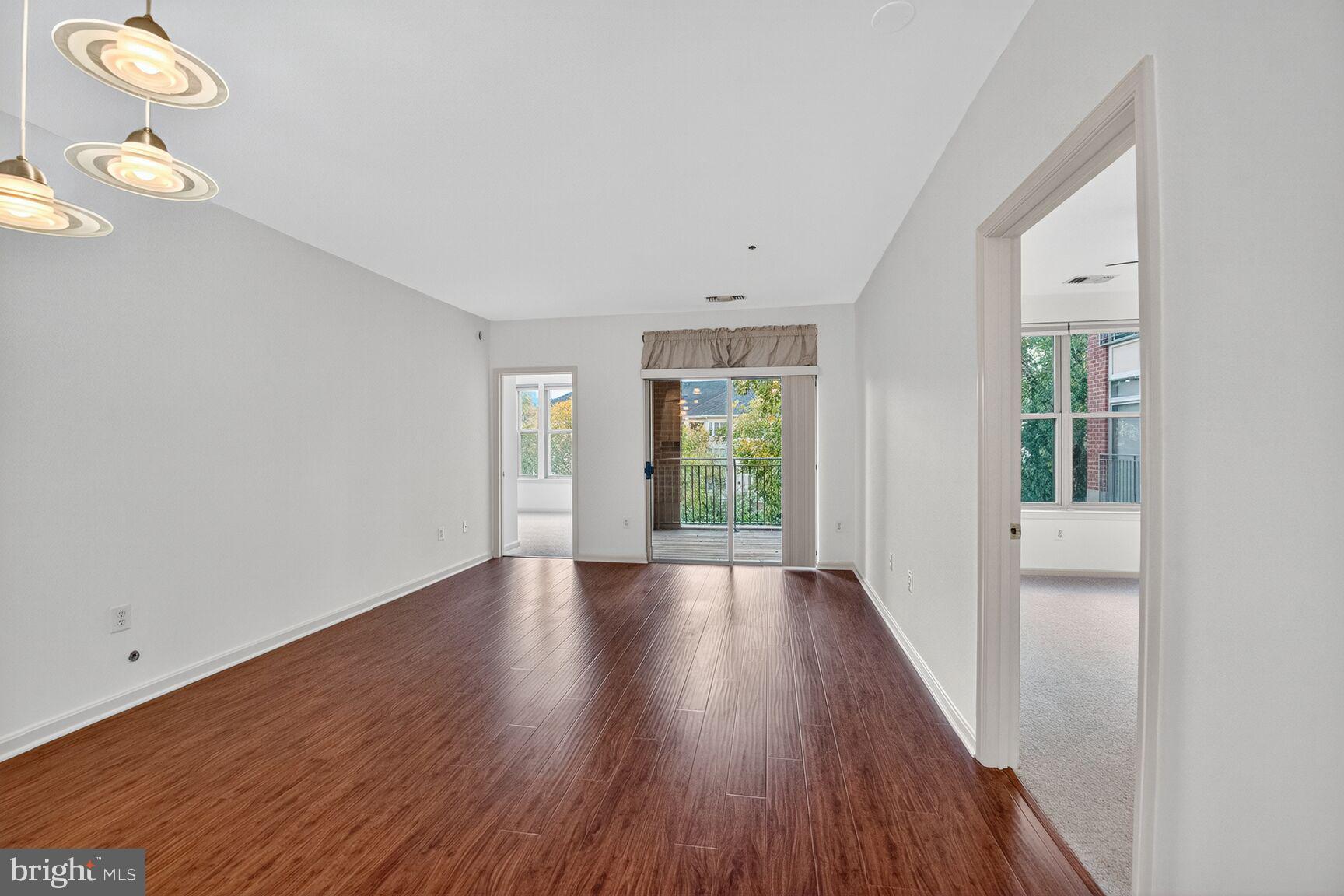 11775 Stratford House Place, Unit 206 Reston, VA 20190 - Photo 12 of 39 a view of an empty room with wooden floor and a window