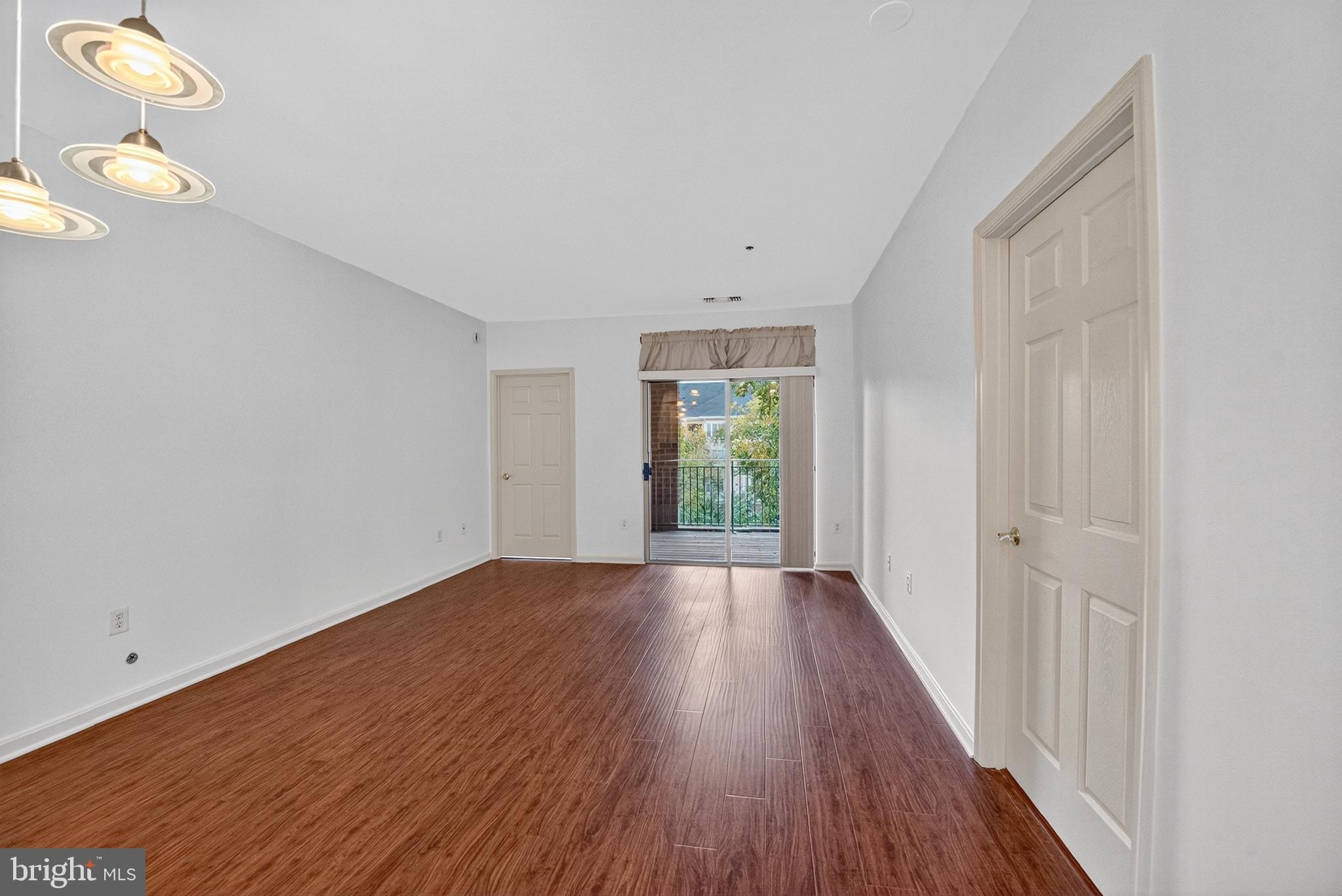 11775 Stratford House Place, Unit 206 Reston, VA 20190 - Photo 13 of 39 a view of an empty room with wooden floor and a window