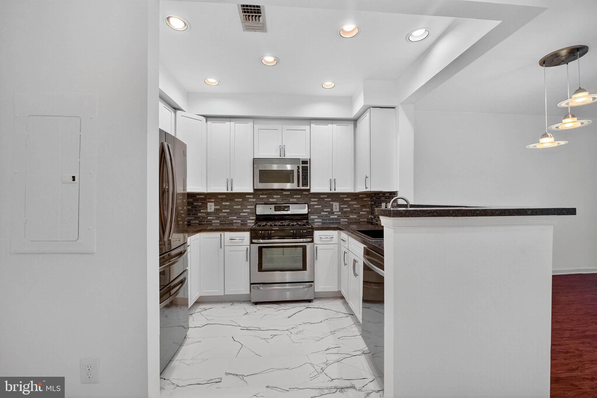 11775 Stratford House Place, Unit 206 Reston, VA 20190 - Photo 8 of 39 a kitchen with white cabinets and stainless steel appliances