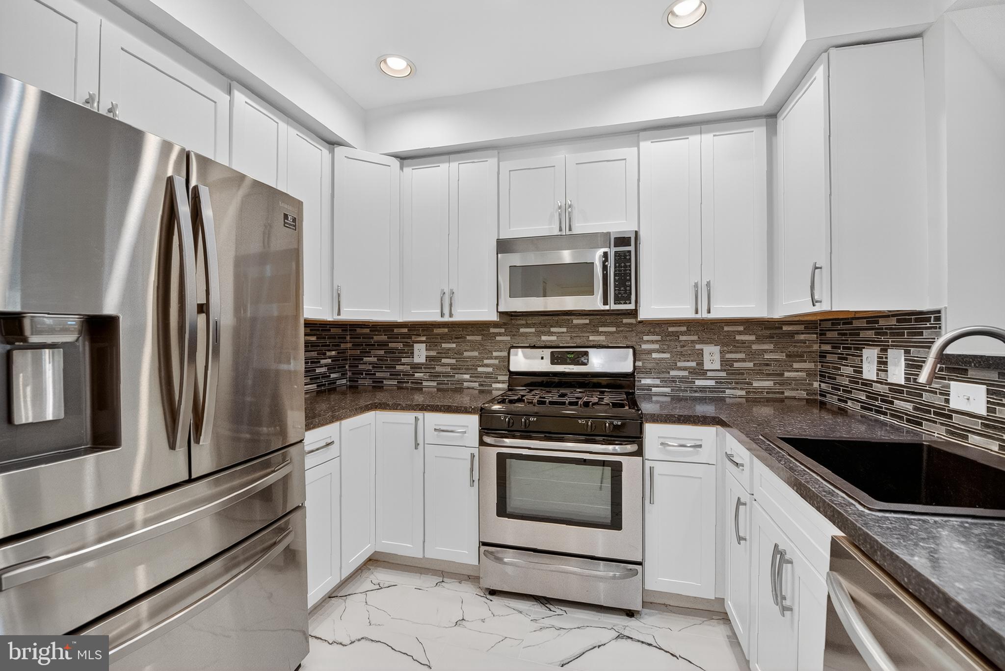 11775 Stratford House Place, Unit 206 Reston, VA 20190 - Photo 9 of 39 a kitchen with stainless steel appliances white cabinets and white appliances