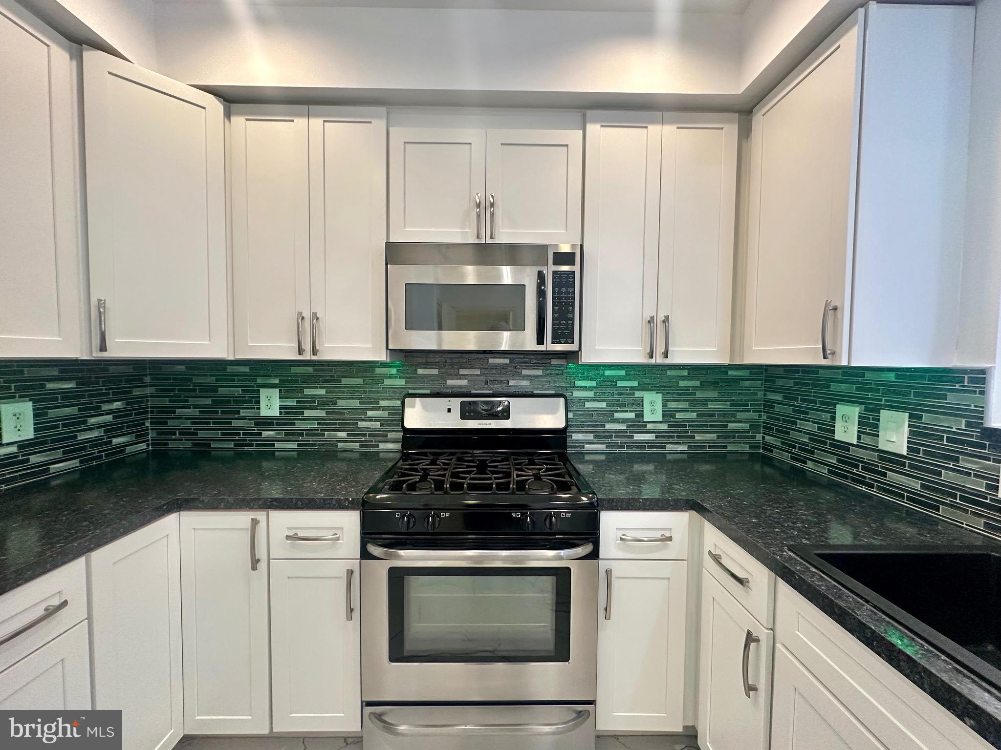 11775 Stratford House Place, Unit 206 Reston, VA 20190 - Photo 10 of 39 a kitchen with granite countertop white cabinets and black appliances