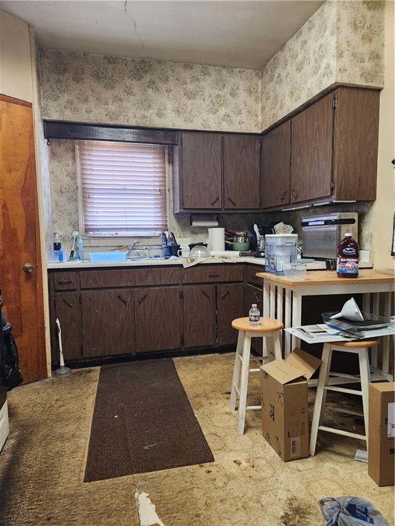 238 East 19th Avenue Homestead, PA 15120 - Photo 3 of 4 a kitchen with a sink a stove and chairs