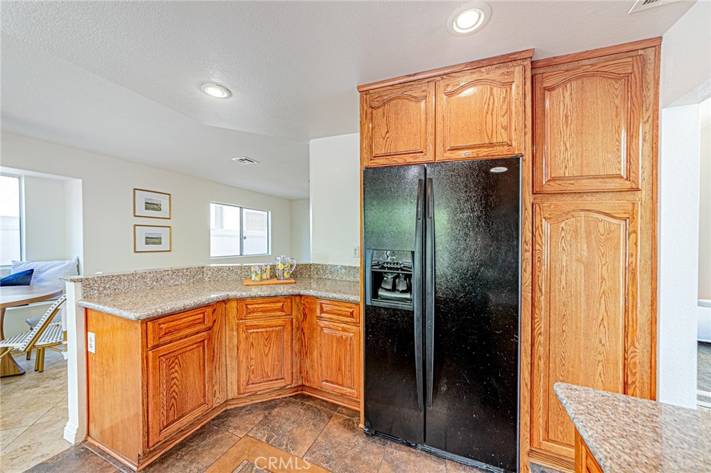 15377 Tobarra Road Fontana, CA 92337 - Photo 11 of 38 Kitchen featuring granite countertops with refrigerator included