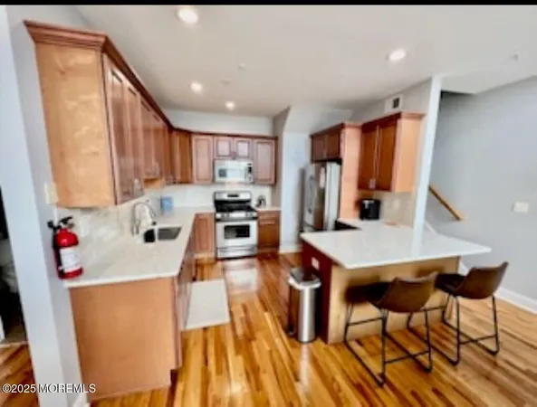 a kitchen that has a microwave a stove and wooden floor