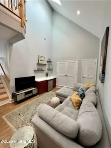 a living room with furniture a flat screen tv and kitchen view