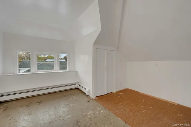 a view of a backyard with plants and large trees