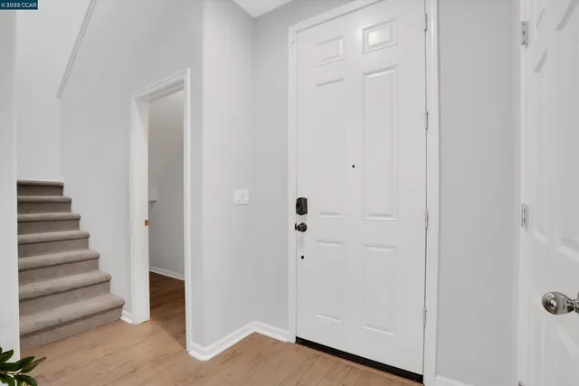 a view of a hallway with wooden floor and entryway