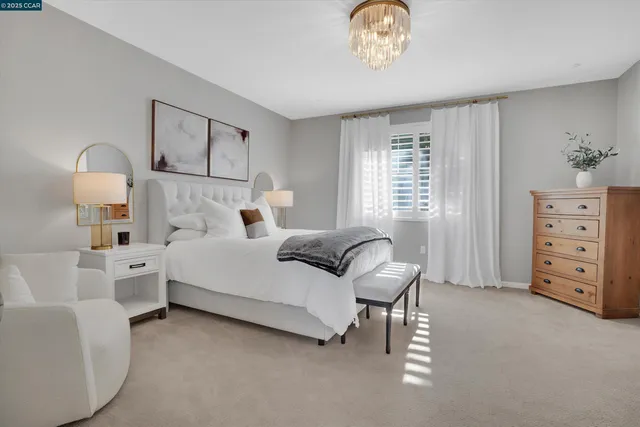 a bedroom with a bed mirror and window