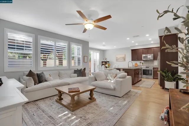 a living room with furniture ceiling fan and a window