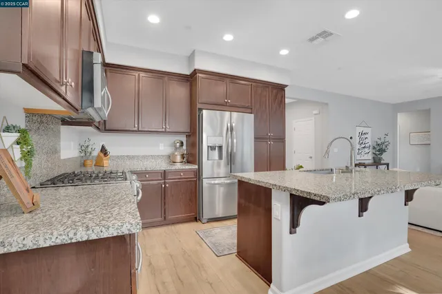 a kitchen with stainless steel appliances granite countertop a sink stove and refrigerator