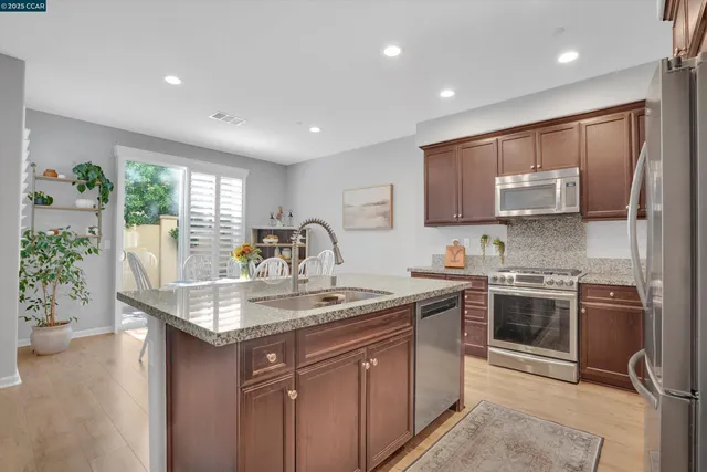 a kitchen with kitchen island granite countertop a sink stove and refrigerator