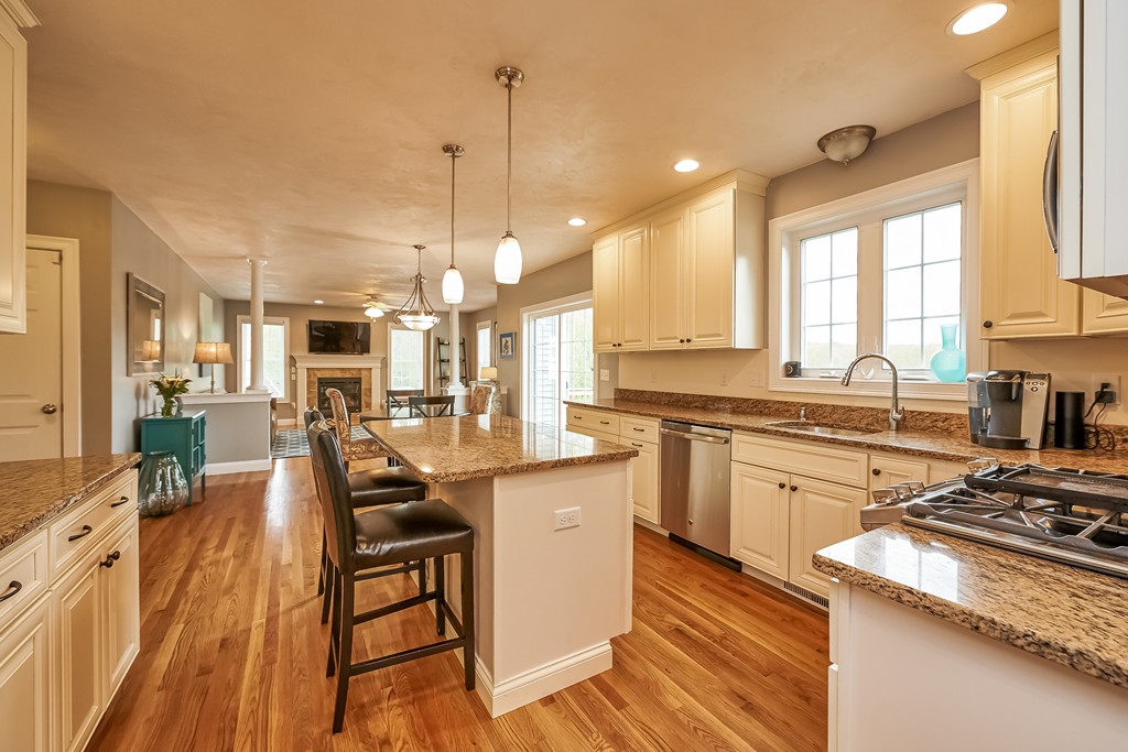13 West Ledge Road Clinton, MA 01510 - Photo 11 of 30 a kitchen with stainless steel appliances granite countertop a stove top oven a sink dishwasher a dining table and chairs with wooden floor