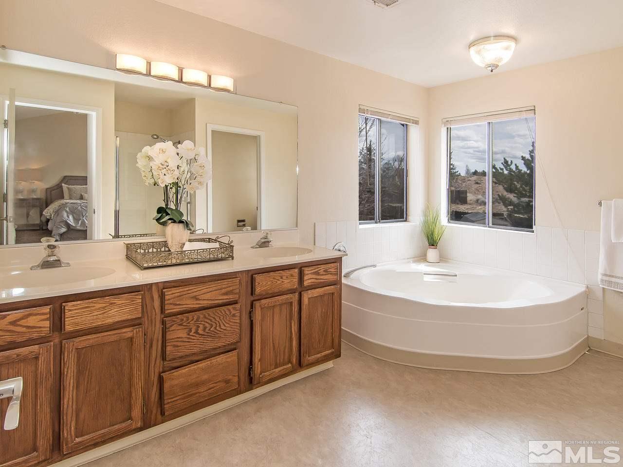 5302 Vista Ridge Way Reno, NV 89523 - Photo 14 of 20 a spacious bathroom with a double vanity sink a mirror a bathtub and next to a window