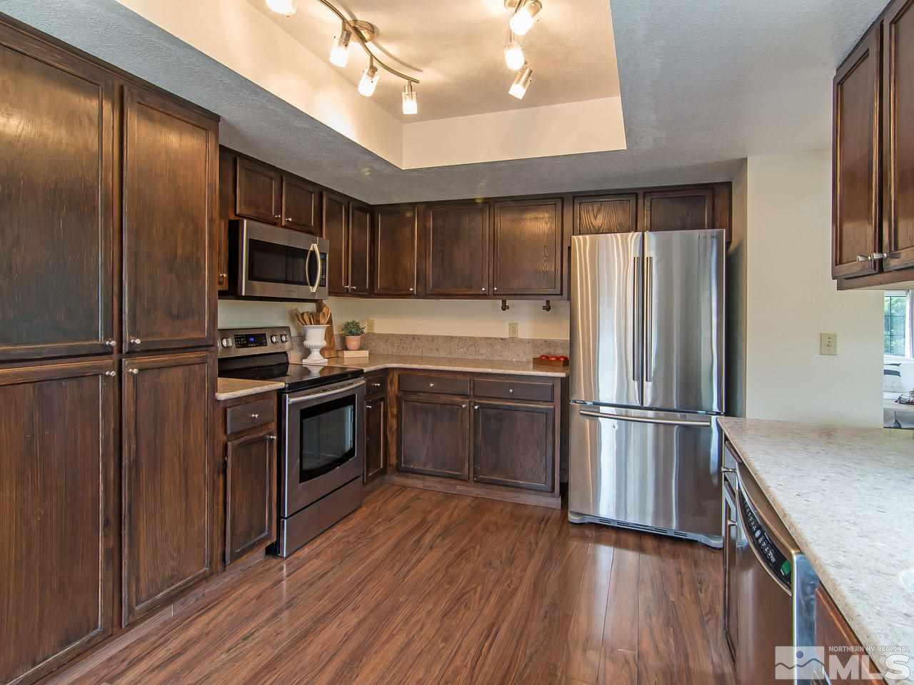 5302 Vista Ridge Way Reno, NV 89523 - Photo 8 of 20 a kitchen with a refrigerator stainless steel appliances wooden floor and cabinets