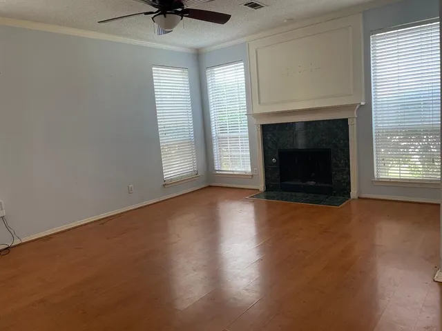 an empty room with windows and fireplace