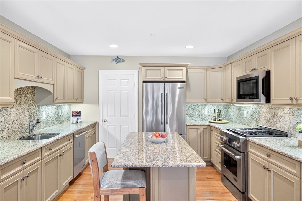 199 East Bay Road, Unit 13 Barnstable, MA 02655 - Photo 13 of 40 a kitchen with stainless steel appliances granite countertop a sink stove microwave and refrigerator