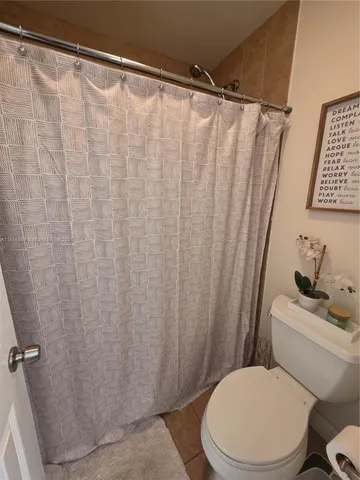 a white toilet sitting next to a shower curtain