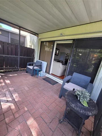 a view of a house with a yard plants and large tree