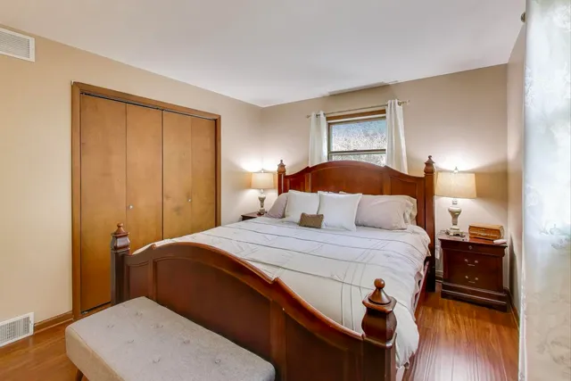 a bedroom with a bed and wooden floor