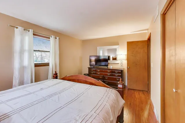 a bedroom with a bed and wooden floor