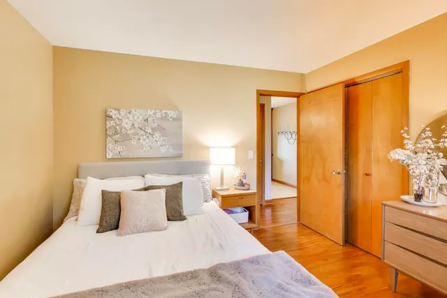 a bedroom with a bed and a painting on the wall