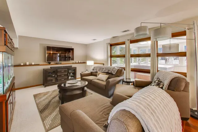 a living room with furniture large windows and a flat screen tv