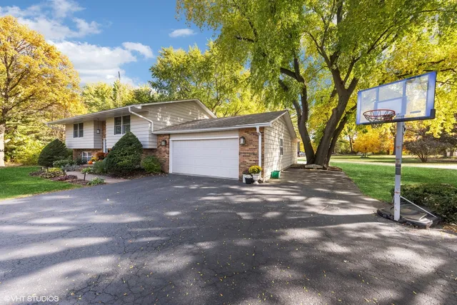 a view of a house with a yard and large tree