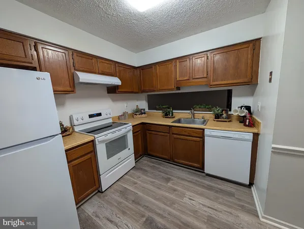 a kitchen with a sink a refrigerator and cabinets