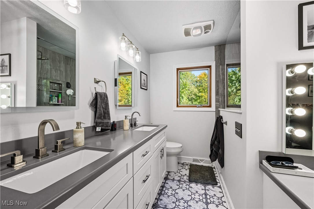 8193 Hartman Road Wadsworth, OH 44281 - Photo 27 of 50 Full bath with a stall shower, double vanity, and light tile patterned floors