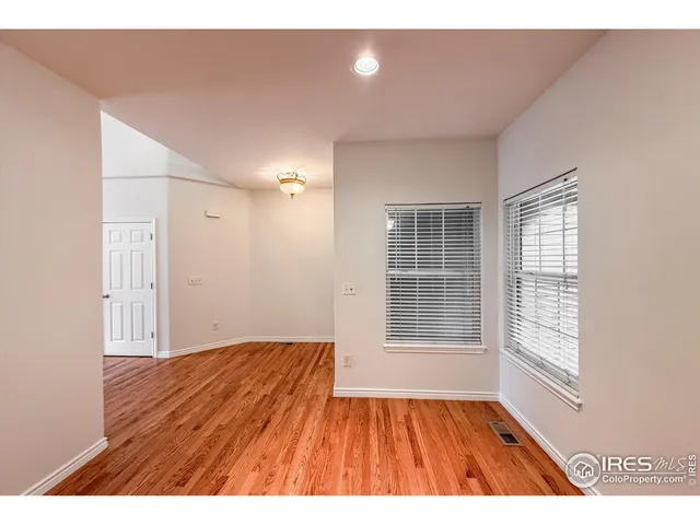 a view of empty room with wooden floor and fireplace
