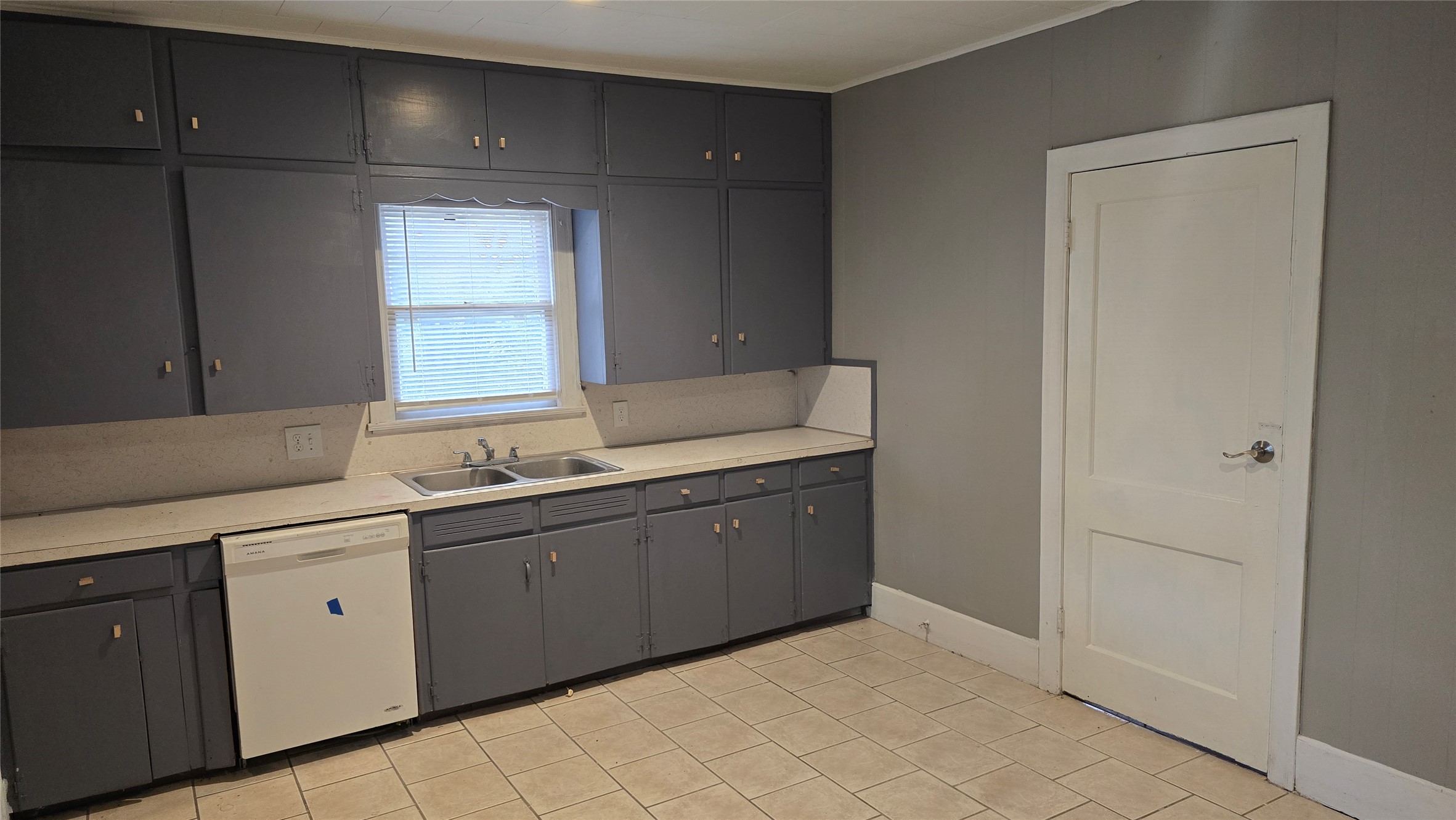 18327 Blake Manor Road, Unit A Manor, TX 78653 - Photo 3 of 21 Kitchen featuring light countertops, white dishwasher, light tile patterned flooring, and gray cabinetry