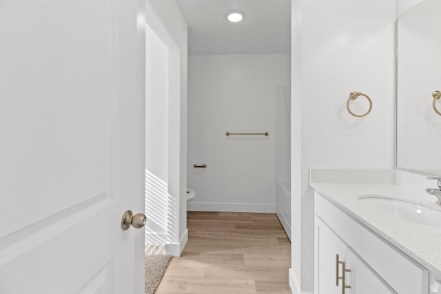 1271 West 500 South Logan, UT 84321 - Photo 15 of 26 Bathroom vanity featuring a white countertop with integrated sink, brushed brass hardware, and a large mirror