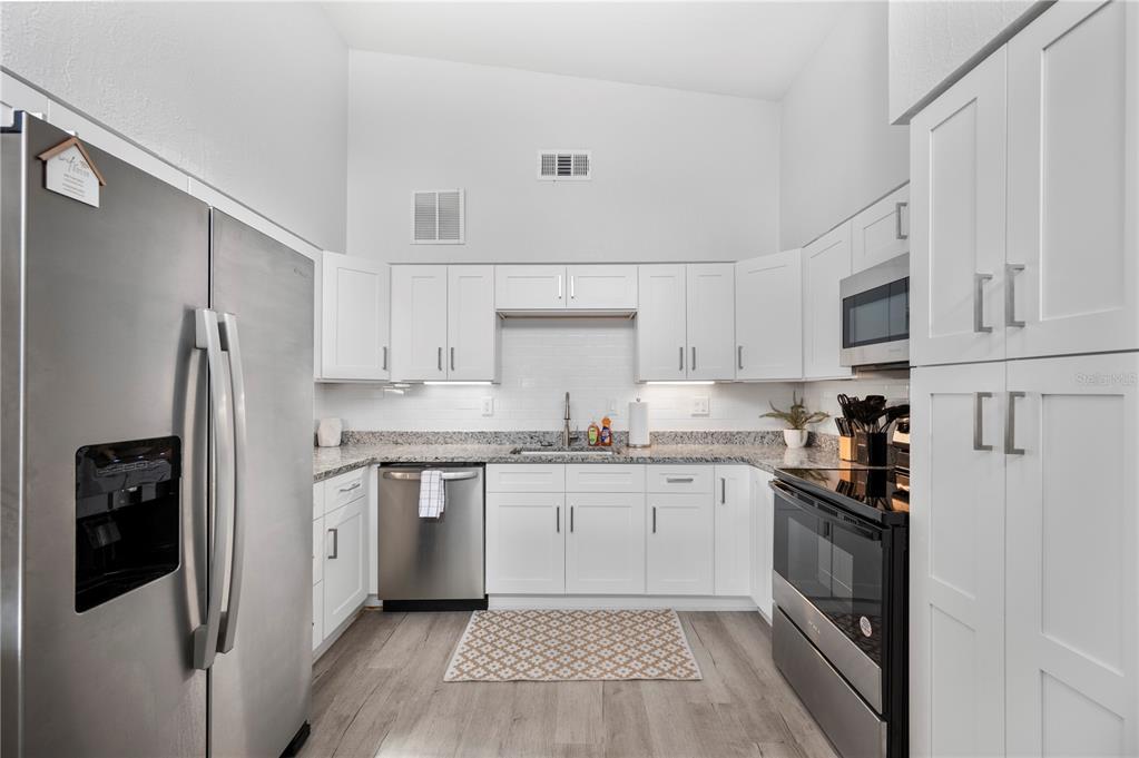 2214 Nottingham Road Lakeland, FL 33803 - Photo 11 of 40 a kitchen with stainless steel appliances granite countertop a refrigerator and a stove top oven