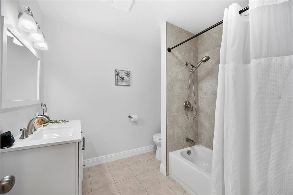 2214 Nottingham Road Lakeland, FL 33803 - Photo 22 of 40 a bathroom with a tub shower sink vanity and mirror