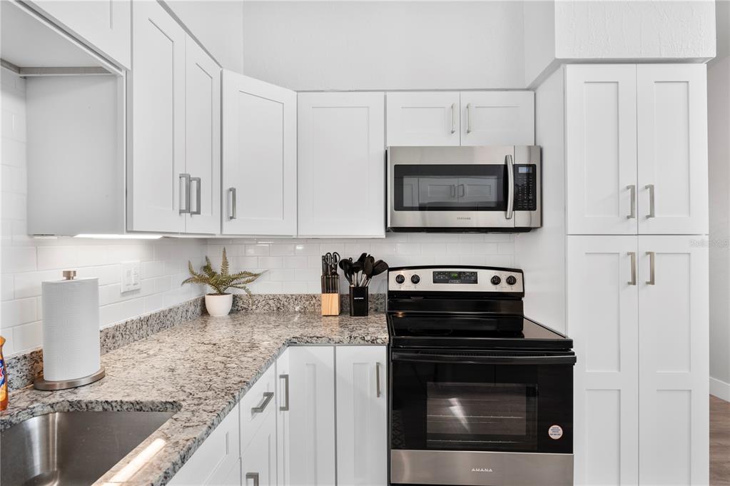 2214 Nottingham Road Lakeland, FL 33803 - Photo 8 of 40 a kitchen with granite countertop white cabinets and stainless steel appliances