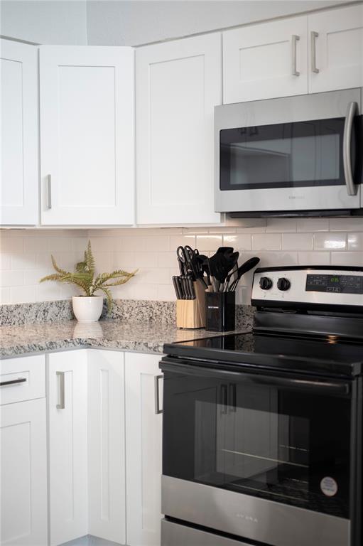 2214 Nottingham Road Lakeland, FL 33803 - Photo 9 of 40 a kitchen with granite countertop a stove microwave and cabinets
