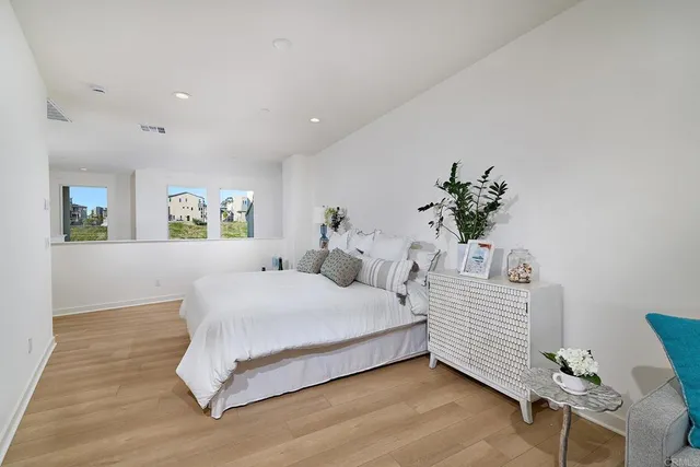 a bedroom with a large bed and a potted plant