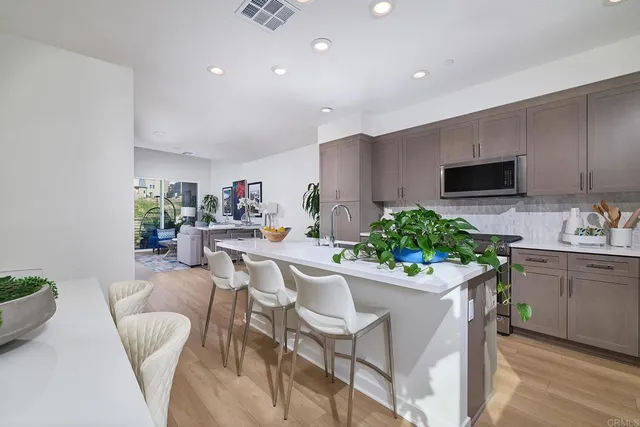a kitchen with stainless steel appliances kitchen island granite countertop a sink and chairs